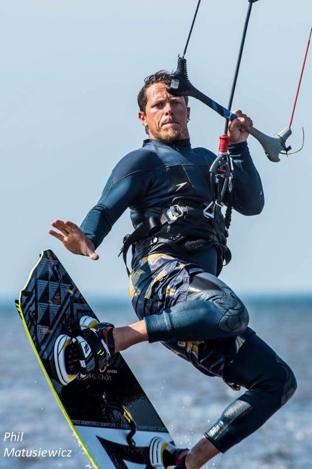 Kiteboarder in blue suit mid-jump